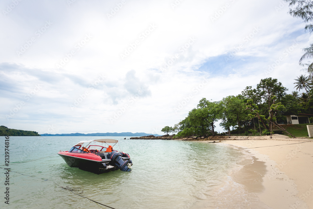 Obraz premium red private small speed boat parking near seaside of island