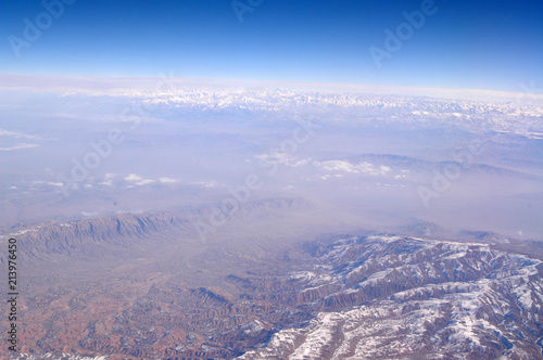 Earth surface with snowy mountains on blue sky, aerial view. Environment protection and ecology. Mountain landscape. Discovery and adventure. Earth day every day