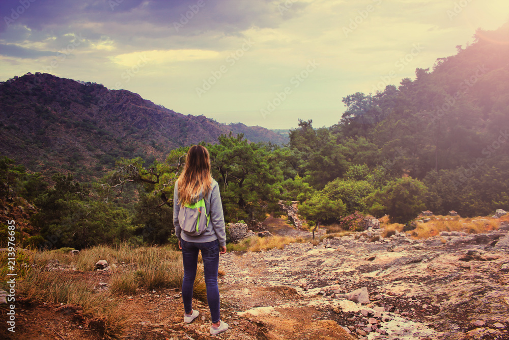 Fototapeta premium Młoda piękna dziewczyna w bluzie z kapturem i plecaku turystycznym patrząc na niesamowity krajobraz z góry Hemera w Turcji.