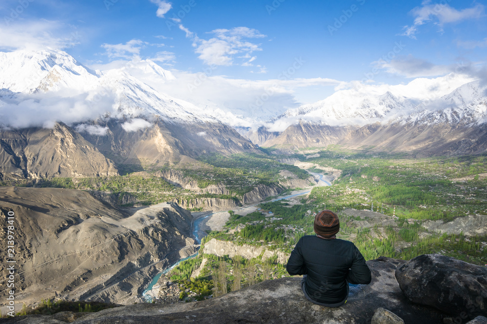 a traveller/hiker enjoys the beautiful view of Hunza valley Pakistan