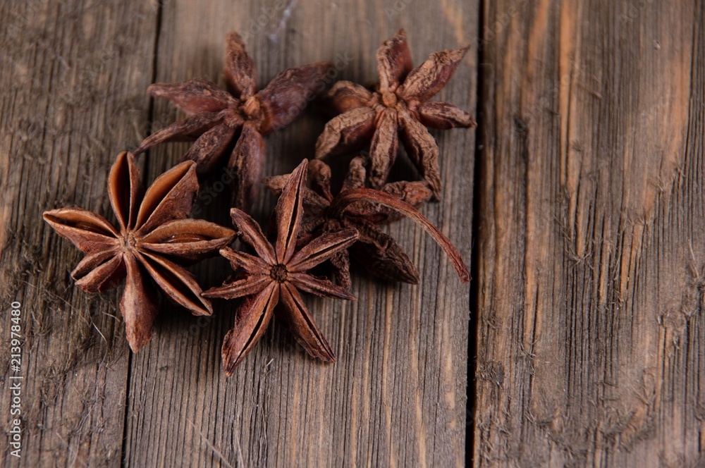Multiple star shaped dried Anise spice laying on wooden table top Multiple star shaped dried Anise spice laying on wooden table top