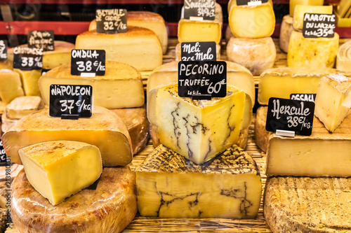 Different cheeses on the counter of a small store at the market. Paris, France