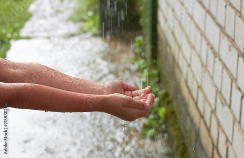 Hands of the child in the rain. © valeriya