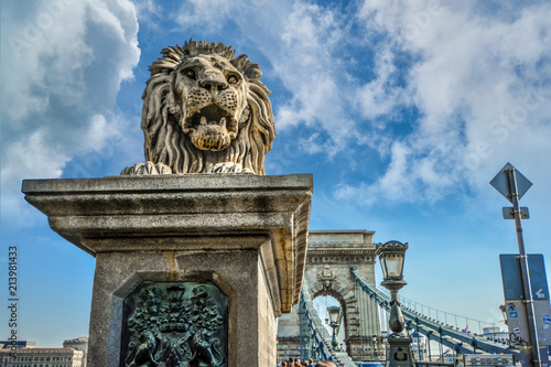 A stone lion stands at the entrance to the Chain Bridge on the Buda side of the Danube in Budapest, Hungary