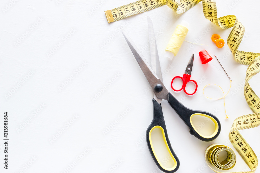 thread sewing needle centimeter scissors on a white background