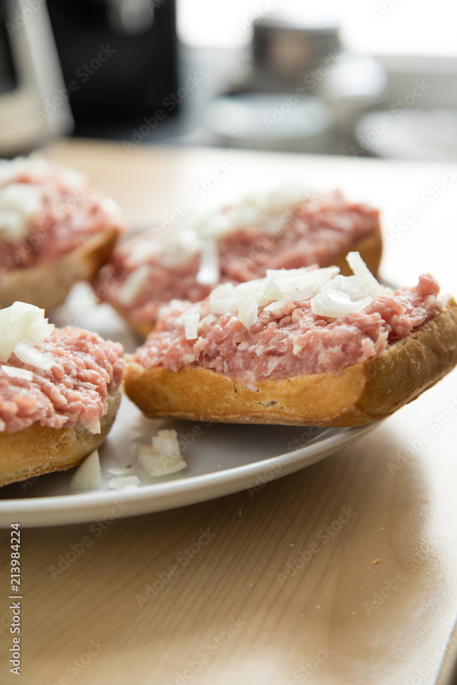 Teller mit 5 Mettbrötchen mit Schweinemett und Zwiebeln auf Küche Arbeitsfläche Teller mit 5 Mettbrötchen mit Schweinemett und Zwiebeln auf Küche Arbeitsfläche