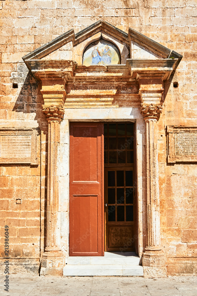 Stone portal and wooden door of an Orthodox monastery on the island of Crete, Greece.