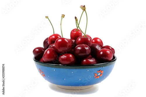 Ripe cherry in a plate on a white background. Front view.