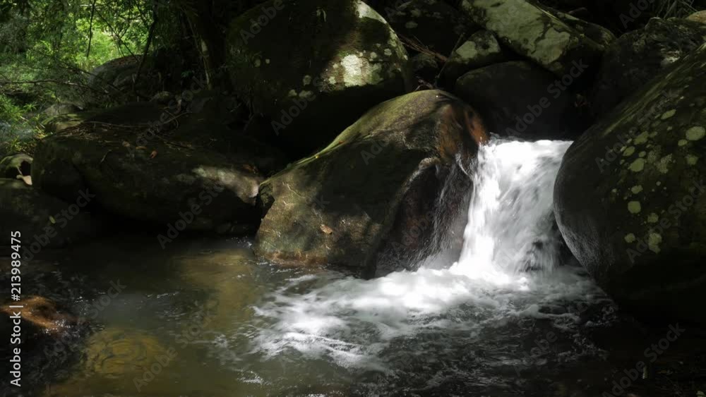 mountain stream creek waterfall flowing through rocks in a tropical forest. mountain stream creek waterfall flowing through rocks in a tropical forest.