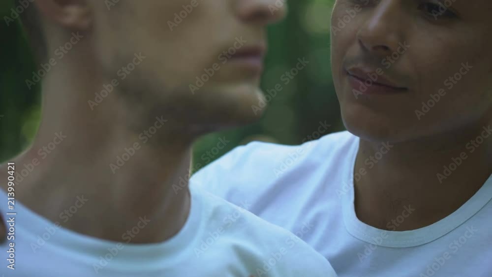 Romantic gay couple hugging and kissing, homosexual partners outdoor, affection Romantic gay couple hugging and kissing, homosexual partners outdoor, affection