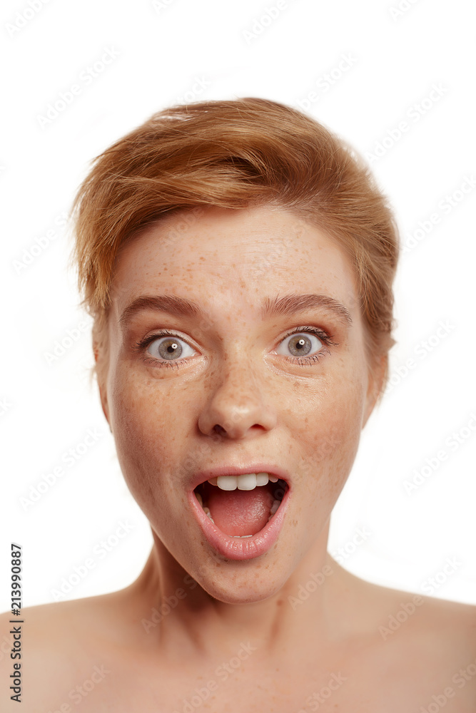 Head portrait of young beautiful surprised woman amazed in shock and surprise with mouth big opened isolated white background in astonished face expression Head portrait of young beautiful surprised woman amazed in shock and surprise with mouth big opened isolated white background in astonished face expression