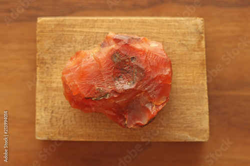 Fotografie Carnelian raw untreated natural stone mineral, a collection of natural stones on a background of natural wood black walnut