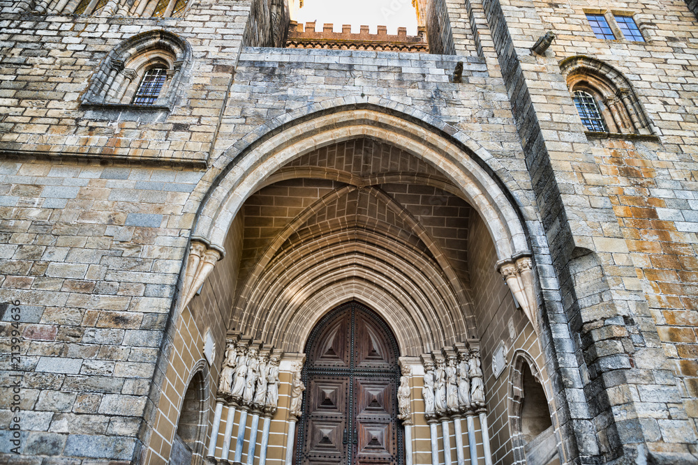 Wooden door on brick wall church in Evora Portugal