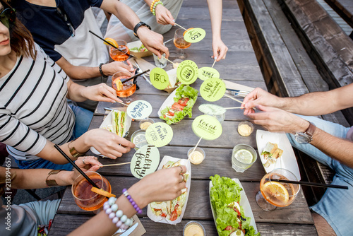 People holding plates with healthy food slogans on the table background full of tasty snacks outdoors