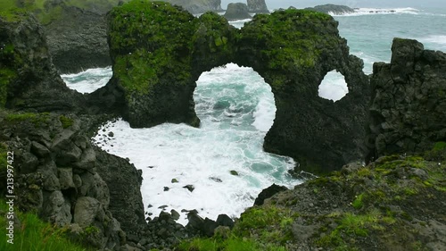 Arnarstapi Arch near Arnarstapi Village at the south Iceland, wave splashing through the hole in rocks photo