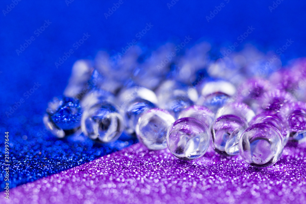 Hydrogel ball rotating on blue and purple surface. Close up macro. Hydrogel ball rotating on blue and purple surface. Close up macro.