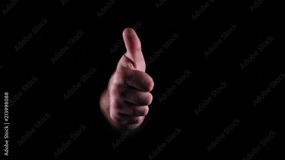 Hand Gestures coming out of the dark into the light. Holding GFX object. Thumbs up into the camera. Hand Gestures coming out of the dark into the light. Holding GFX object. Thumbs up into the camera.
