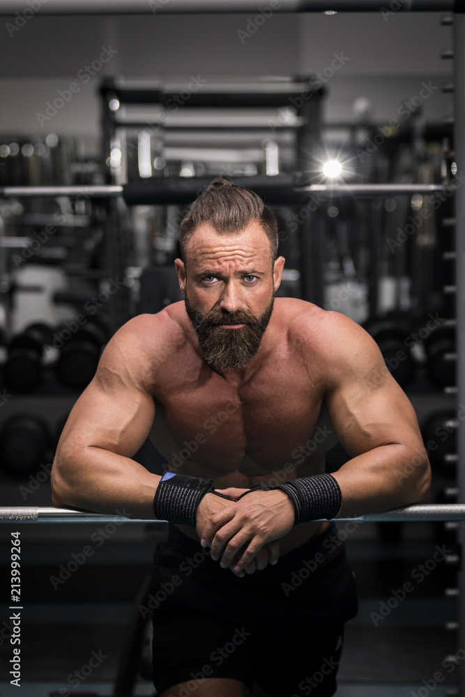 Hombre fuerte con grandes músculos mirando de frente en el gimnasio. Hombre fuerte con grandes músculos mirando de frente en el gimnasio.