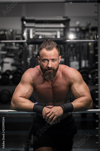 Fototapeta Naklejka Na Ścianę i Meble -  Hombre fuerte con grandes músculos mirando de frente en el gimnasio.