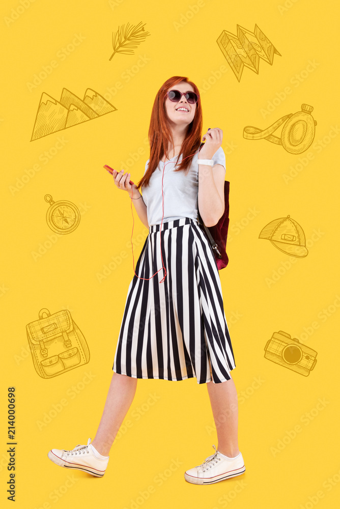 Walking with music. Optimistic emotional traveler smiling and feeling relaxed while listening to music during the walk Walking with music. Optimistic emotional traveler smiling and feeling relaxed while listening to music during the walk
