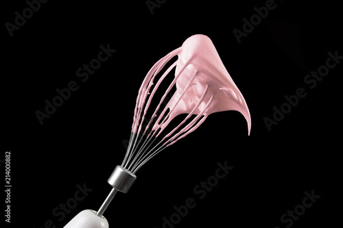 Whipped eggs with sugar on the whisk of the mixer.