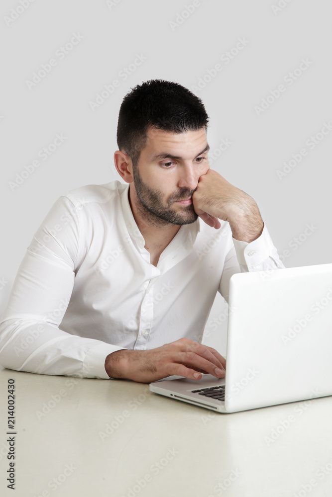 Studio portrait of young businessman in front of his laptop
Studio portrait of young businessman in front of his laptop