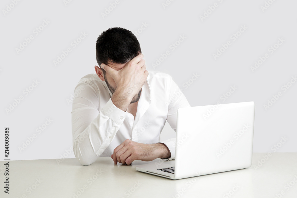 Office life - portrait of young businessman struggling with a project Office life - portrait of young businessman struggling with a project