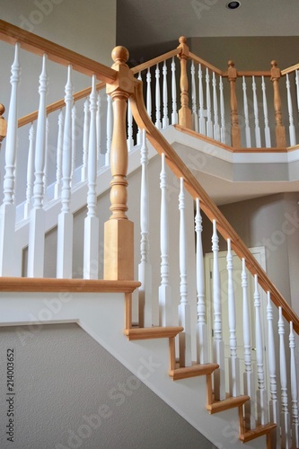 Interior staircase of home with newel post and white spindles