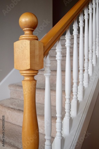 Newel post and white spindles on interior home staircase