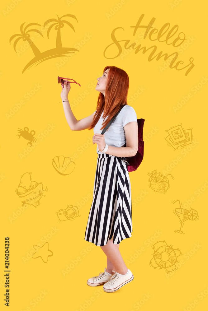 Visiting new places. Pretty young girl wearing casual clothes and a little backpack while walking alone with sunglasses in her hands Visiting new places. Pretty young girl wearing casual clothes and a little backpack while walking alone with sunglasses in her hands