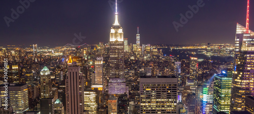 View of Manhattan skyline at night. The entire city is awash in light with the Empire State Building in center of frame.