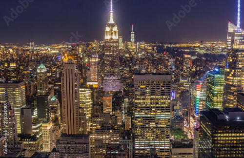 View of Manhattan skyline at night. The entire city is awash in light with the Empire State Building in center of frame.