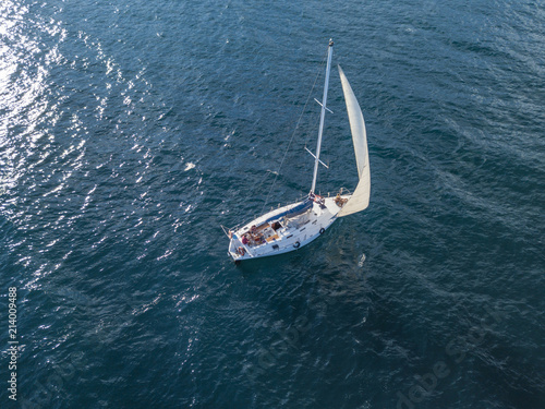 lonely isolated yacht under the sail with tall mast going in still sea aerial top view © Mihail