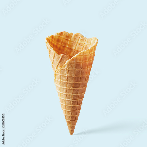 Wafer ice cream cone on a blue background. Minimalistic concept. photo