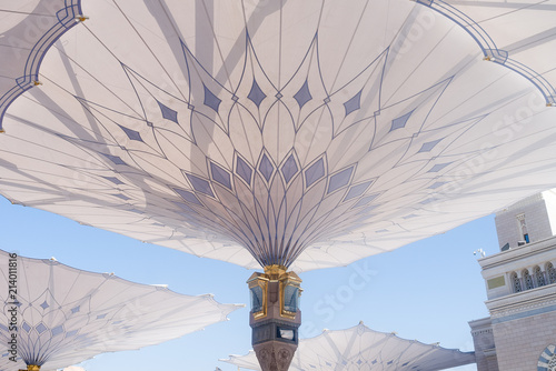 MEDINA, SAUDI ARABIA - APRIL 28 2018: These Umbrella construction on the square of Al-Masjid An-Nabawi or Prophet Muhammed Mosque are protecting people from sun at daytime and work as lights at night