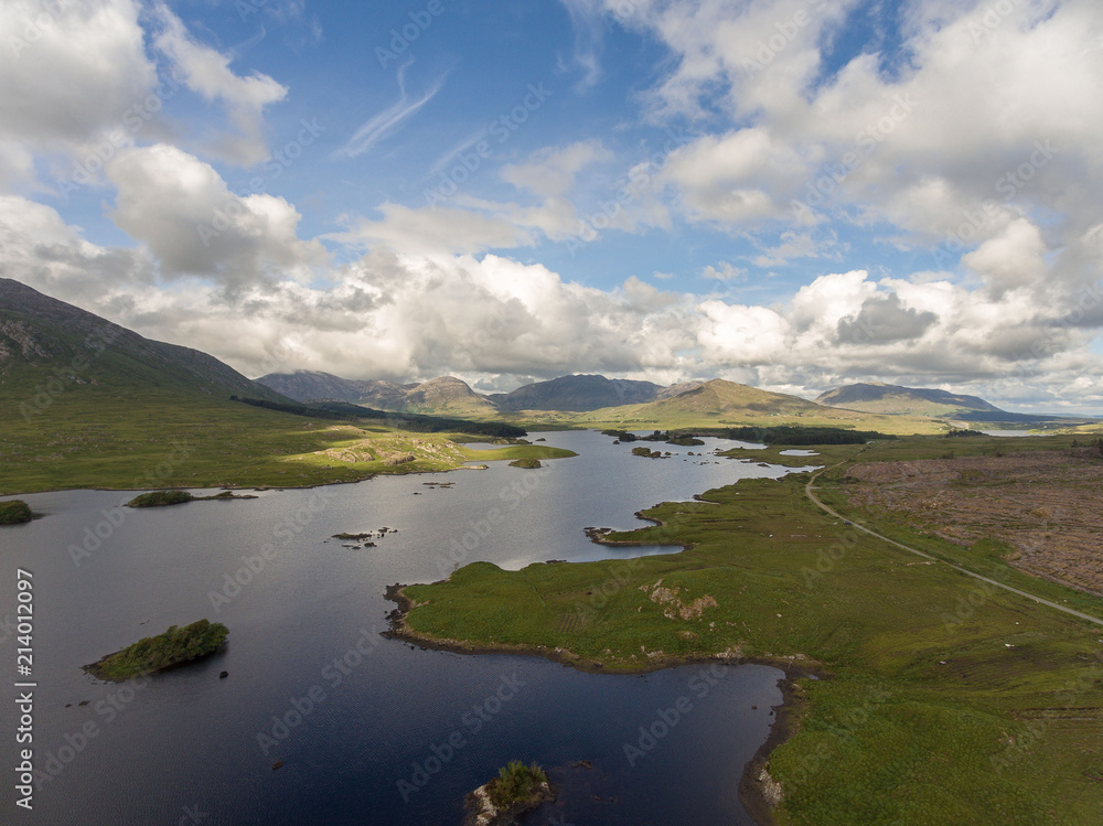 Aerial birds eye scenic view from Connemara National Park in County Galway, Ireland. Beautiful Irish rural nature countryside landscape with mountains in the distance.