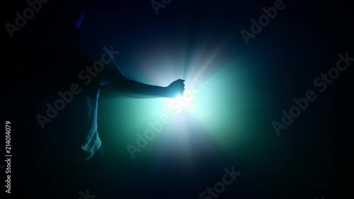 male Hands forming a light orb with pratical effects foggy background with a projectior lightsource in the distance photo