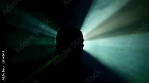 shadowmen with lightrays lurking in the shadows - foggy background with a projectior lightsource in the distance