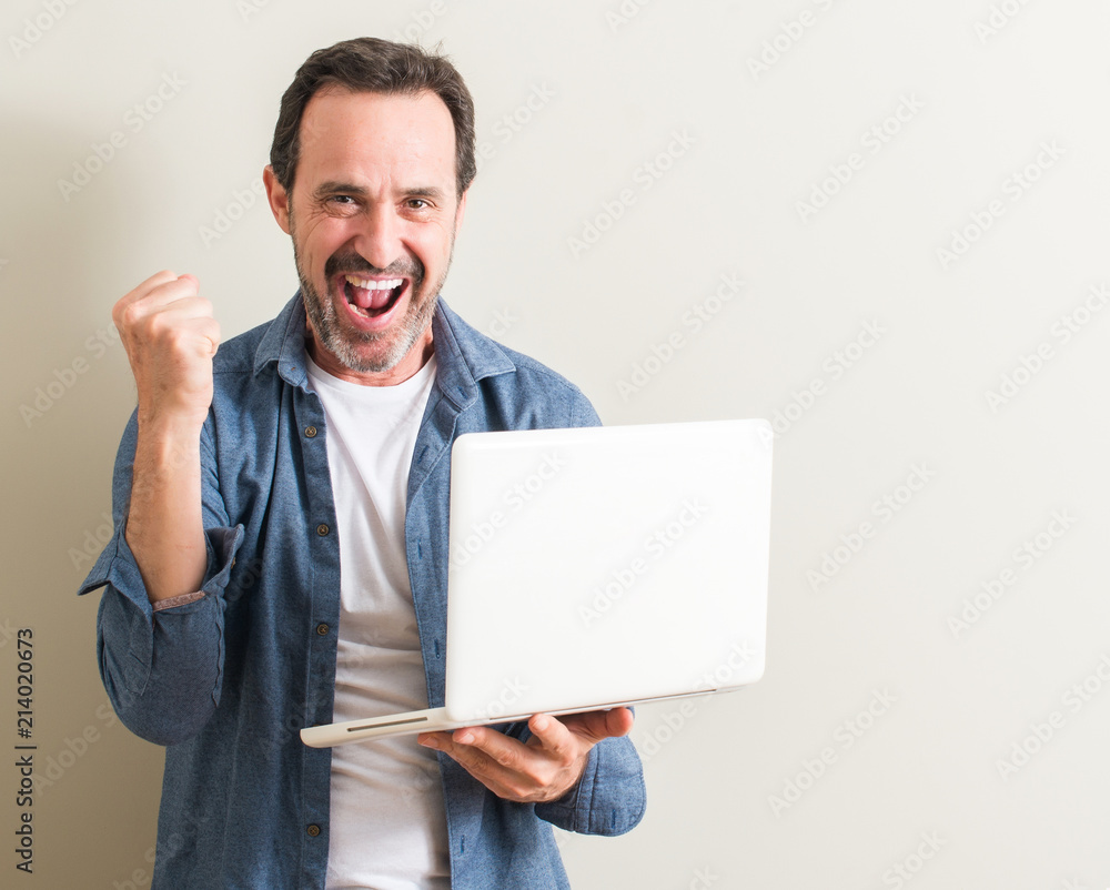 Senior man using laptop computer screaming proud and celebrating victory and success very excited, cheering emotion Senior man using laptop computer screaming proud and celebrating victory and success very excited, cheering emotion