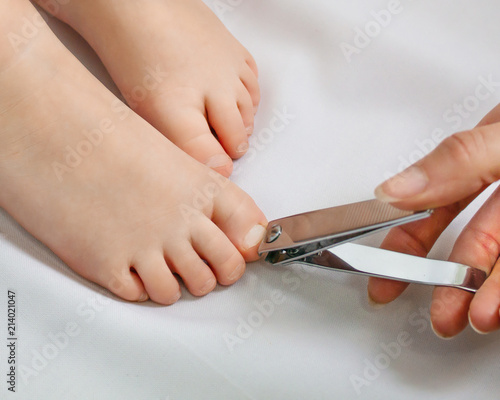 Cut nails on the feet of a child. Caring for the baby.