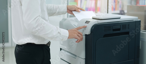 Fotografie, Obraz Bussiness man Hand press button on panel of printer scanner or laser copy machin