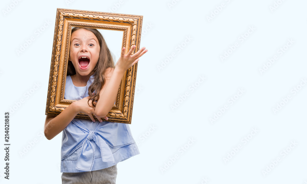 Brunette hispanic girl holding vintage art frame very happy and excited, winner expression celebrating victory screaming with big smile and raised hands