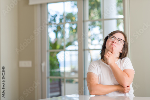 Down syndrome woman at home serious face thinking about question  very confused idea