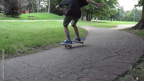 slow motion of a younk guy during his skateboarding training photo