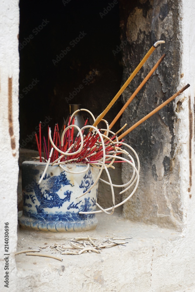 Incense sticks burning in a wall niche at a Buddhist temple in Hanoi Vietnam