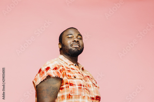 Konstfotografi Portrait of a cool  plus size man in orange shirt on pink background