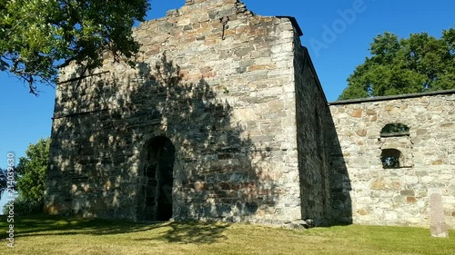 Old church ruin Nes Kirkeruiner entrance summer day with trees and gravestone photo