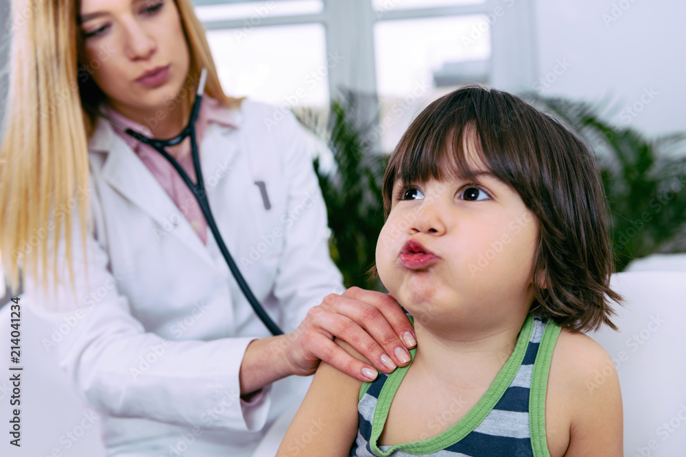 Pediatrician examining little boy with stethoscope Pediatrician examining little boy with stethoscope