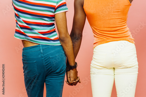 Fotografia Back view of two men holding hands , isolated on pink