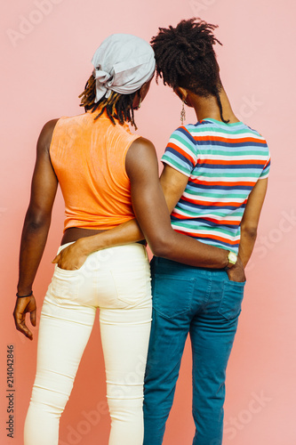 Full body back portrait of two non-conforming men embracing